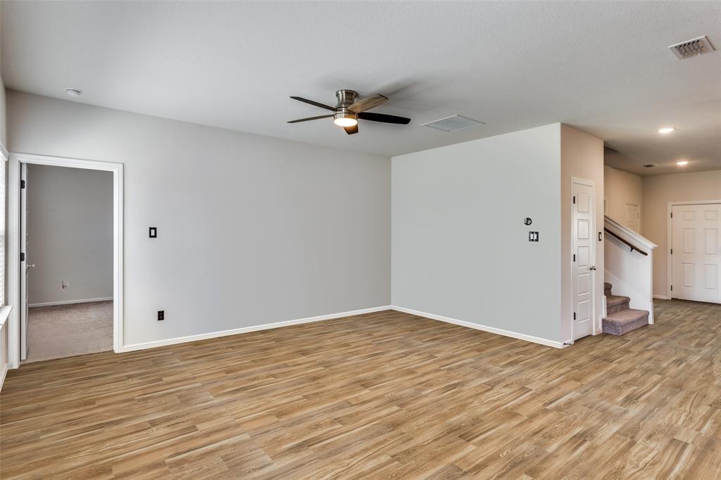 516 Palmito Ranch Road Fort Worth, TX 76131 - Photo 7 of 32 an empty room with wooden floor and a ceiling fan