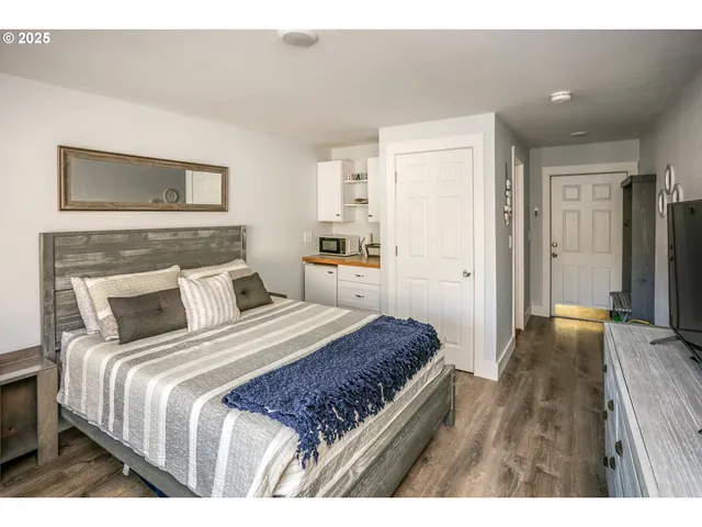 a bedroom with a large bed and wooden floor