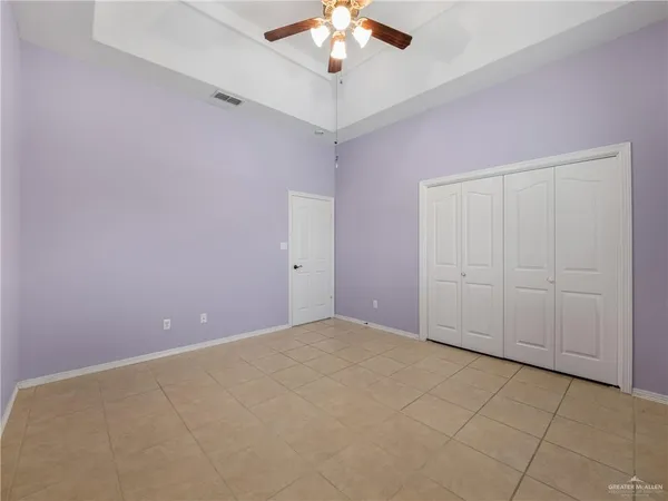 a view of an empty room with a chandelier fan