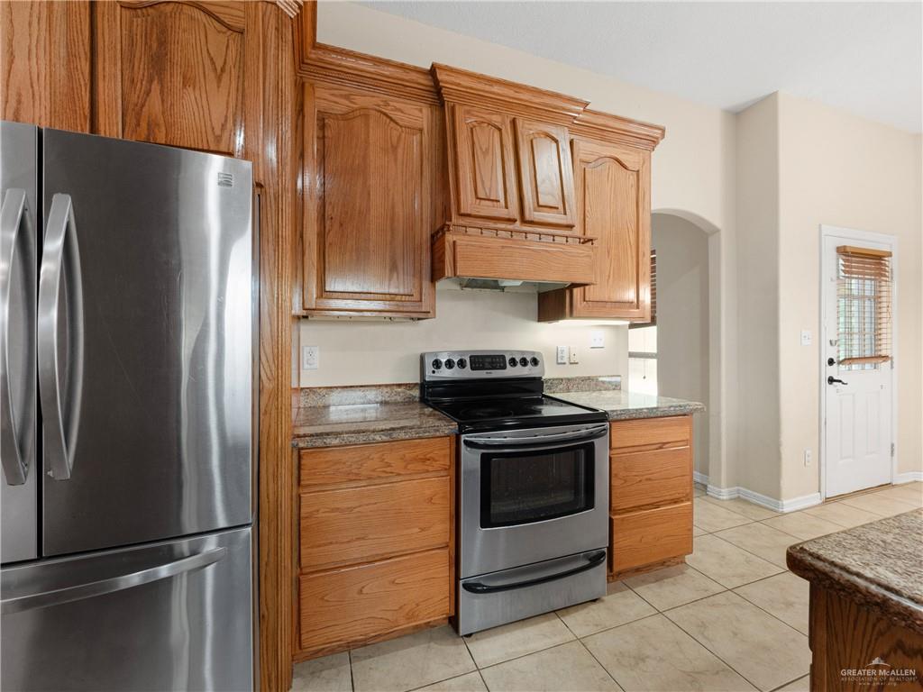 4414 Water's Edge Harlingen, TX 78552 - Photo 8 of 32 a kitchen with stainless steel appliances granite countertop a refrigerator stove and cabinets