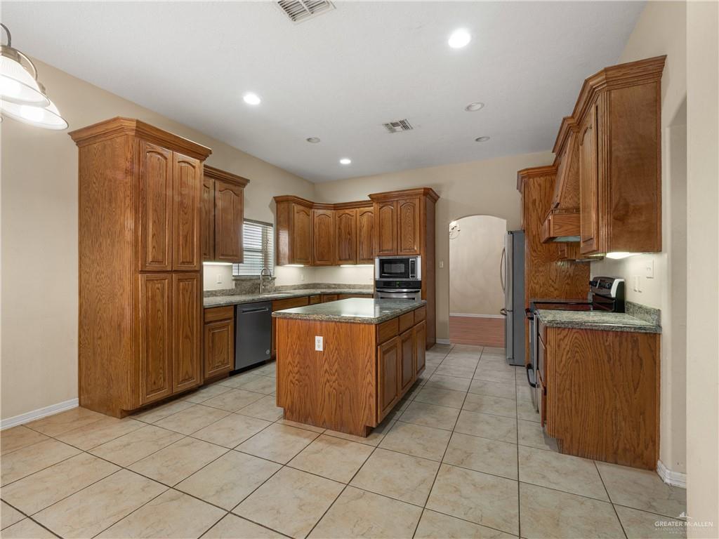 4414 Water's Edge Harlingen, TX 78552 - Photo 10 of 32 a kitchen with stainless steel appliances granite countertop a refrigerator and a sink