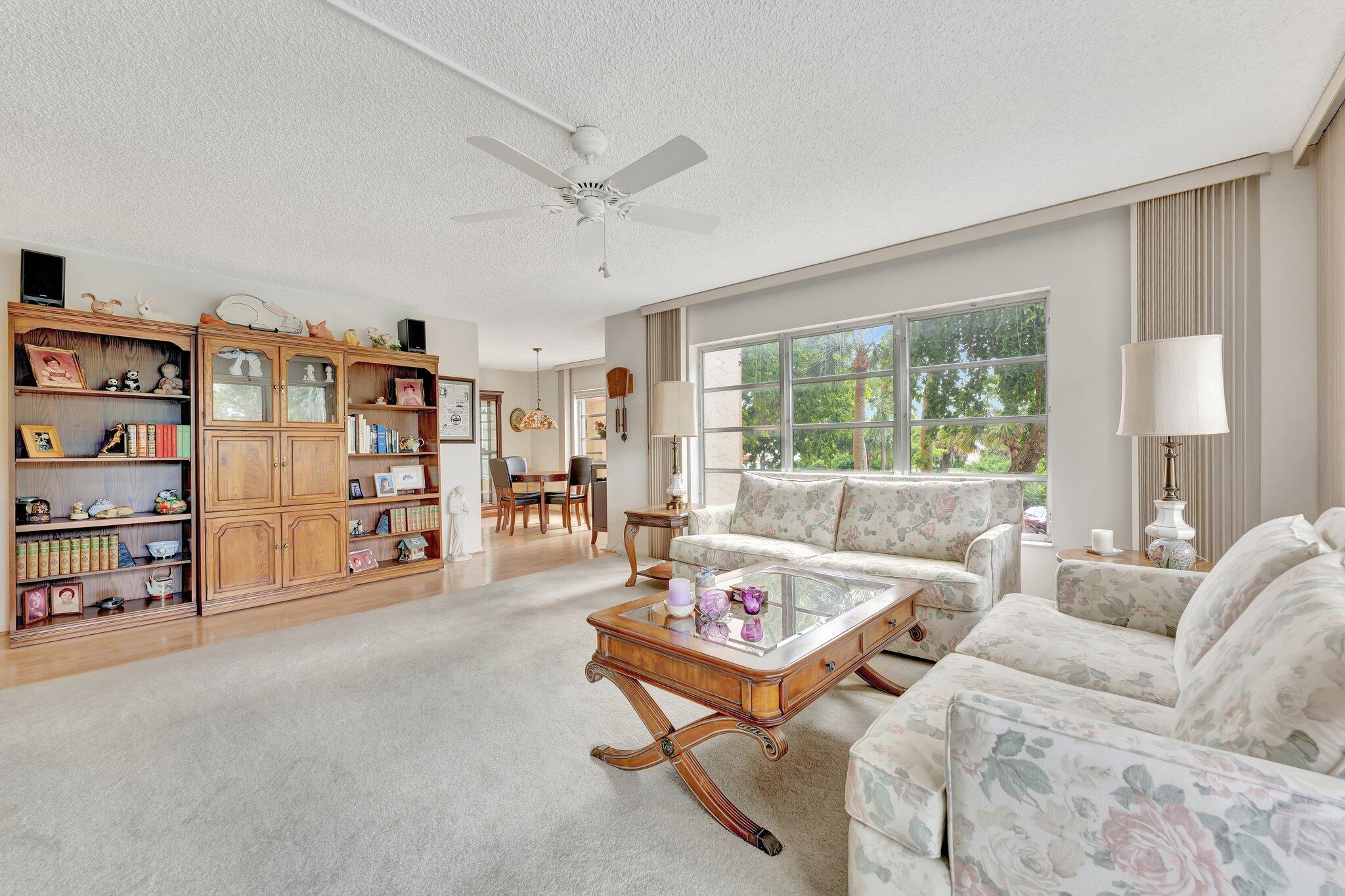 10777 West Sample Road, Unit 207 Coral Springs, FL 33065 - Photo 16 of 48 a living room with furniture and a lamp