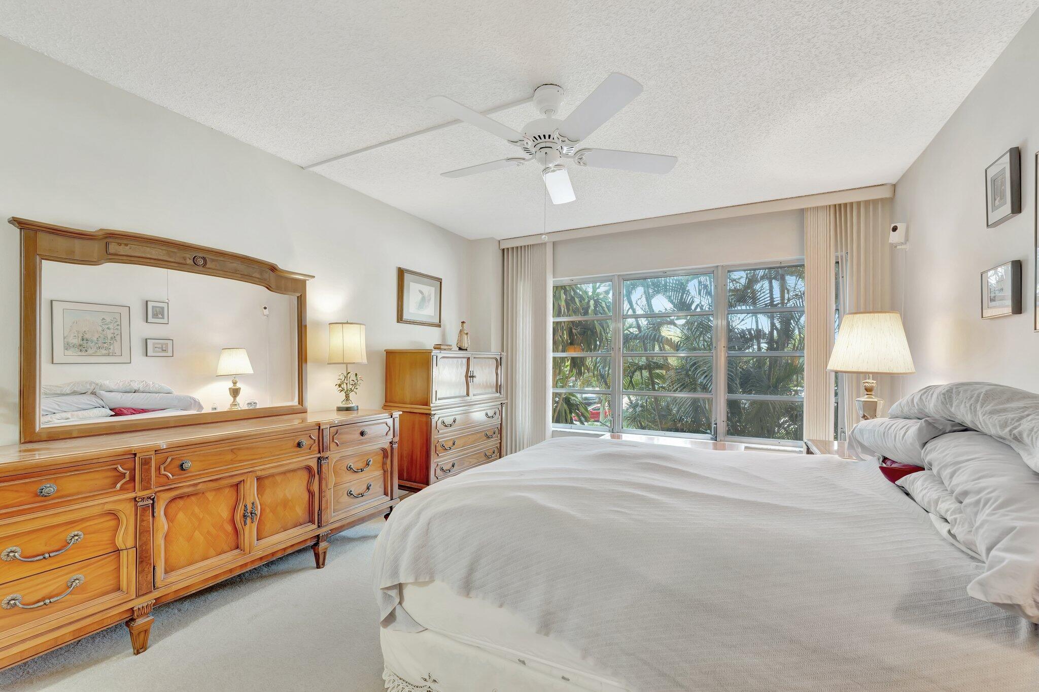 10777 West Sample Road, Unit 207 Coral Springs, FL 33065 - Photo 18 of 48 a bed room with a bed and a large window