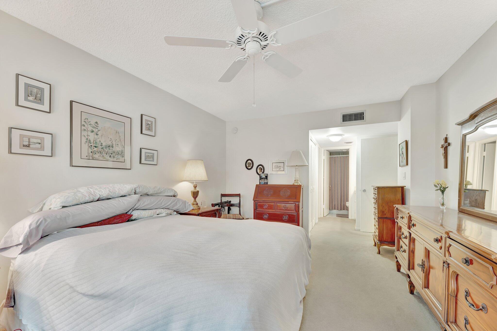 10777 West Sample Road, Unit 207 Coral Springs, FL 33065 - Photo 19 of 48 a bedroom with bed and a chandelier