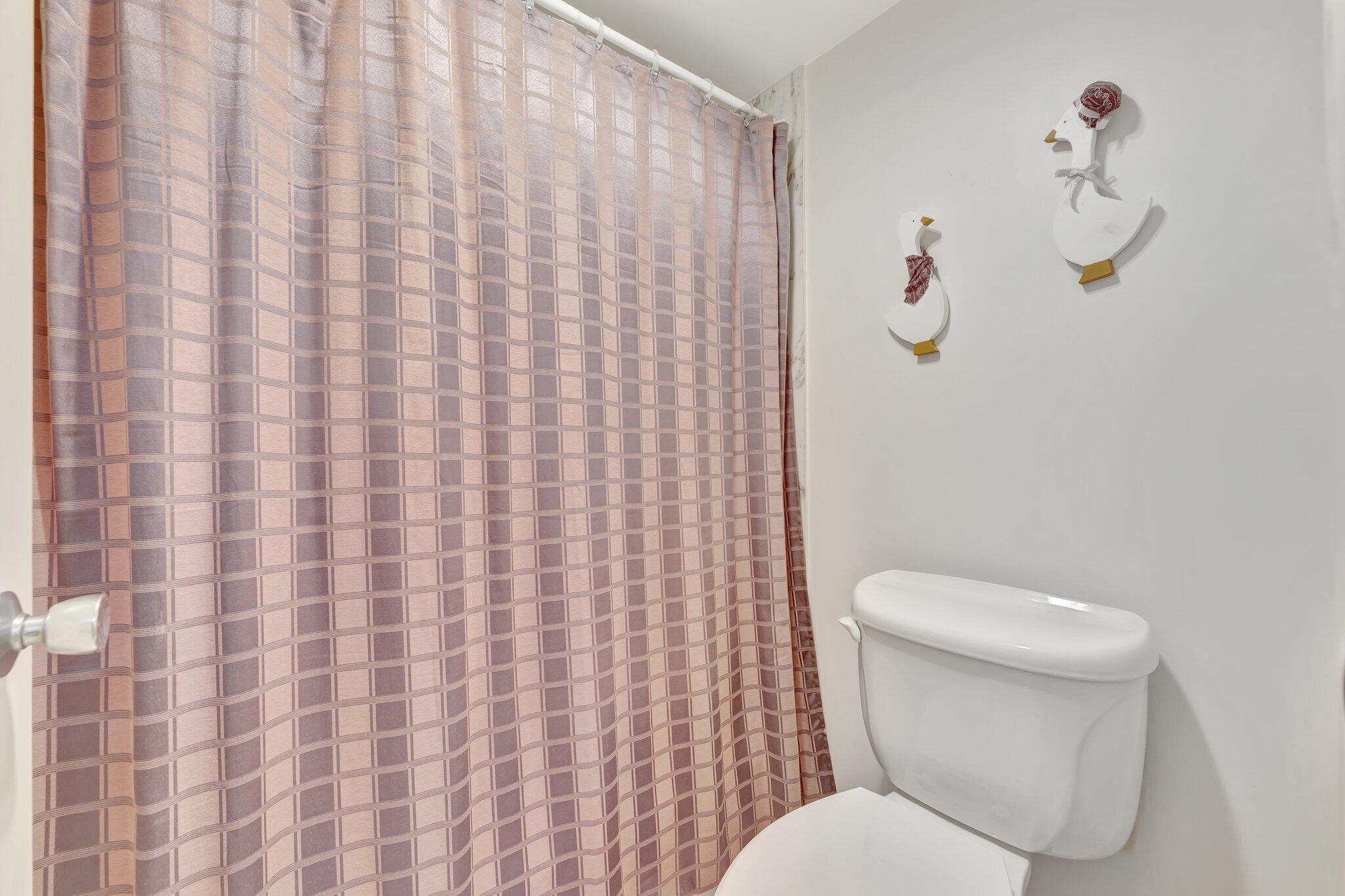 10777 West Sample Road, Unit 207 Coral Springs, FL 33065 - Photo 21 of 48 a white toilet sitting next to a shower curtain