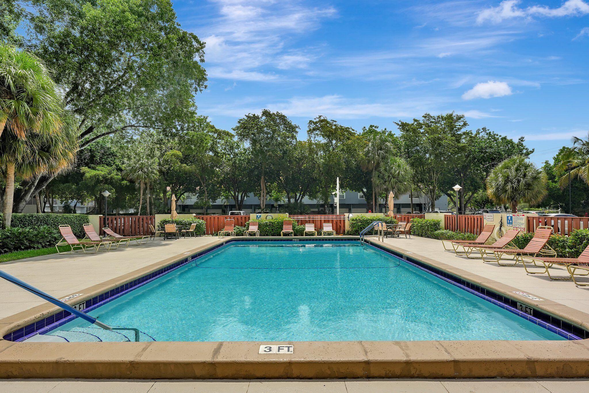 10777 West Sample Road, Unit 207 Coral Springs, FL 33065 - Photo 37 of 48 a view of a swimming pool with chairs