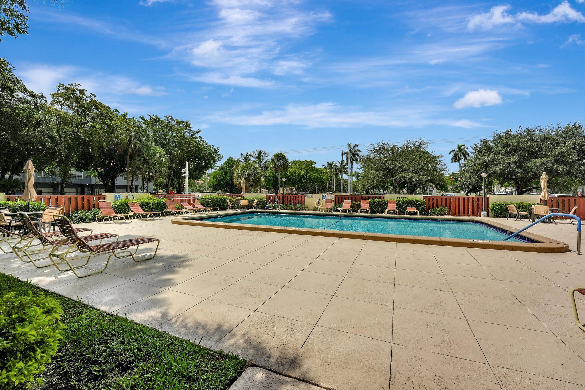 10777 West Sample Road, Unit 207 Coral Springs, FL 33065 - Photo 39 of 48 a view of a swimming pool with an outdoor seating