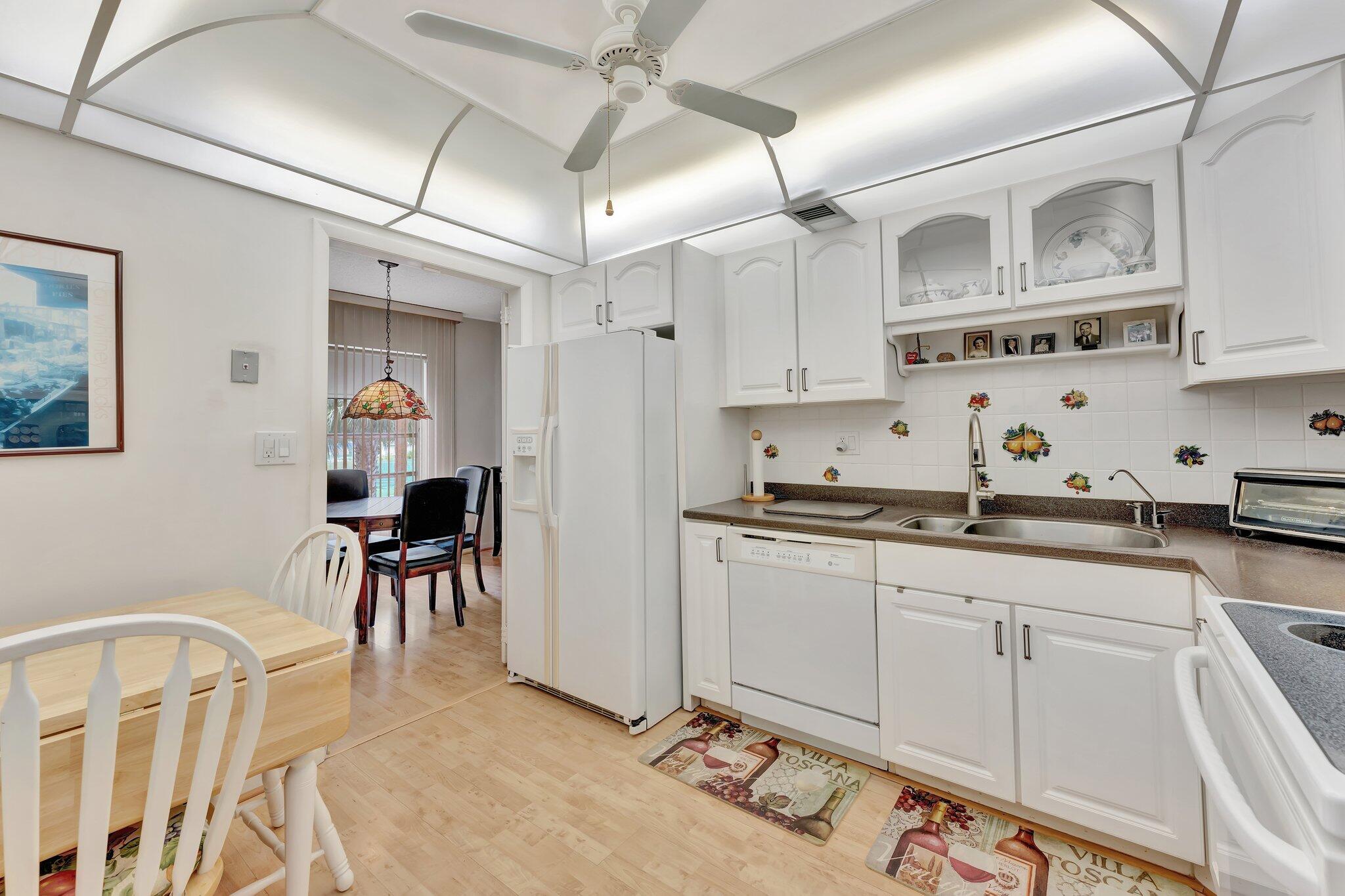 10777 West Sample Road, Unit 207 Coral Springs, FL 33065 - Photo 10 of 48 a kitchen with stainless steel appliances granite countertop a sink and cabinets