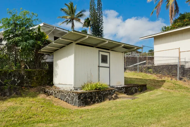 a white house that has a small yard and a large tree