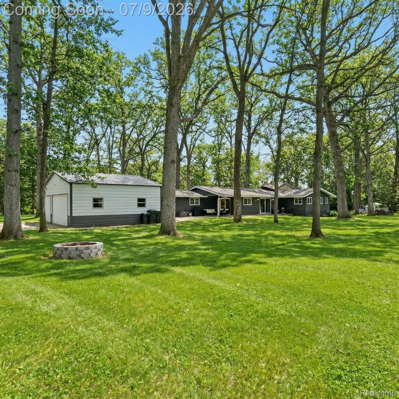 2566 Harrington Road Rochester, MI 48307 - Photo 63 of 64 View of grassy yard featuring the garage, fire pit, and large open space