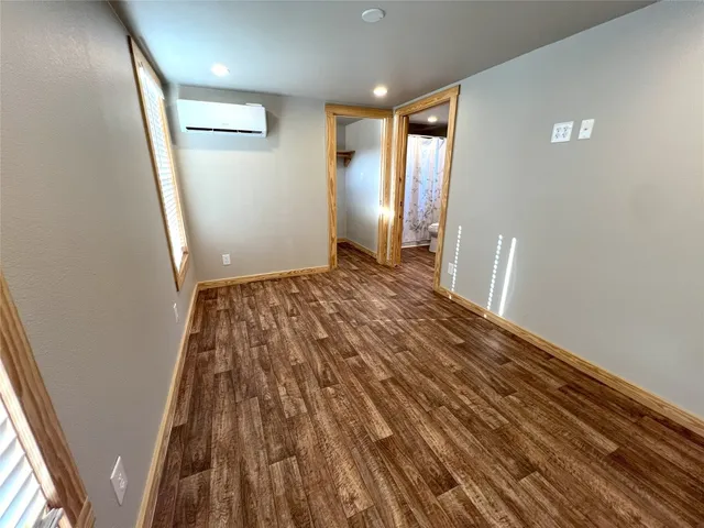 a view of empty room with wooden floor