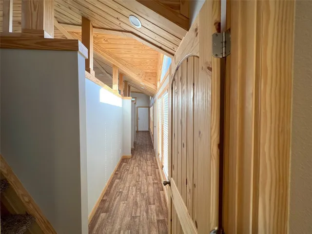 a view of a hallway with wooden floor and staircase