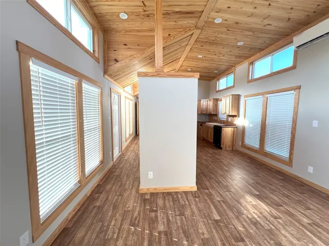 a view of a livingroom with wooden floor and furniture
