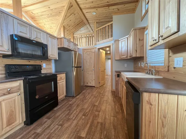 a kitchen with stainless steel appliances granite countertop a refrigerator a stove top oven a sink and dishwasher