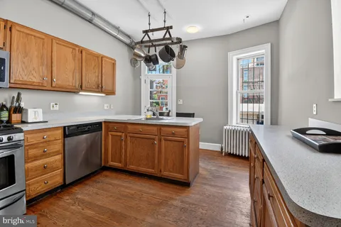a kitchen with stainless steel appliances granite countertop a sink stove and cabinets