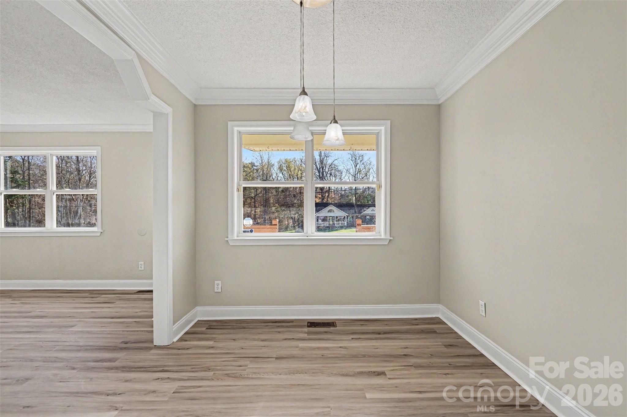 1050 Legion Club Road Salisbury, NC 28146 - Photo 10 of 29 an empty room with wooden floor chandelier and windows