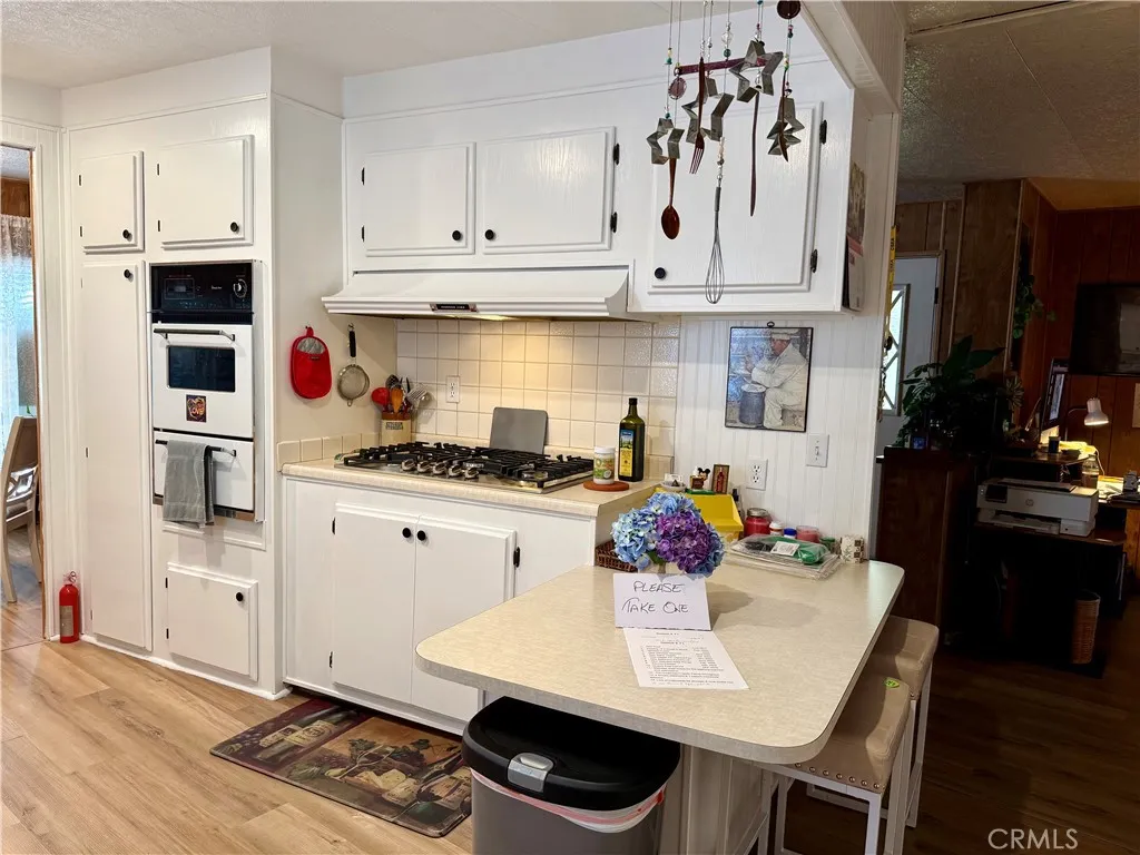 15181 Van Buren Riverside, CA 92504 - Photo 8 of 26 a kitchen with white cabinets and appliances