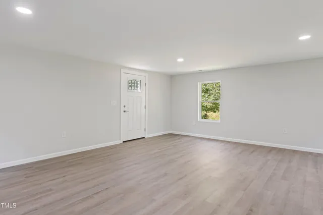 a view of an empty room with wooden floor