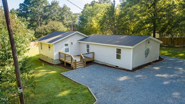 a view of a house with backyard and deck