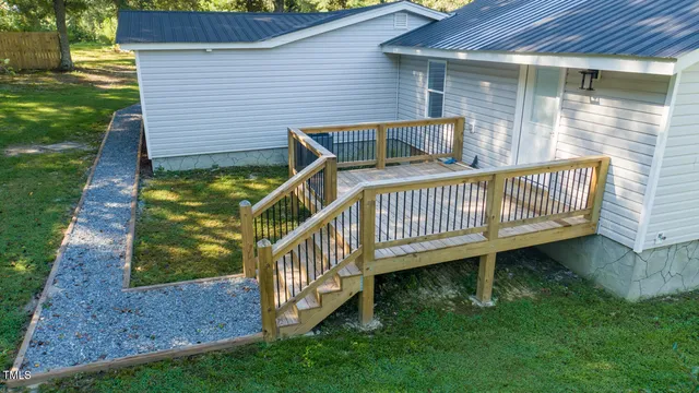 a view of a small house with yard and a garden