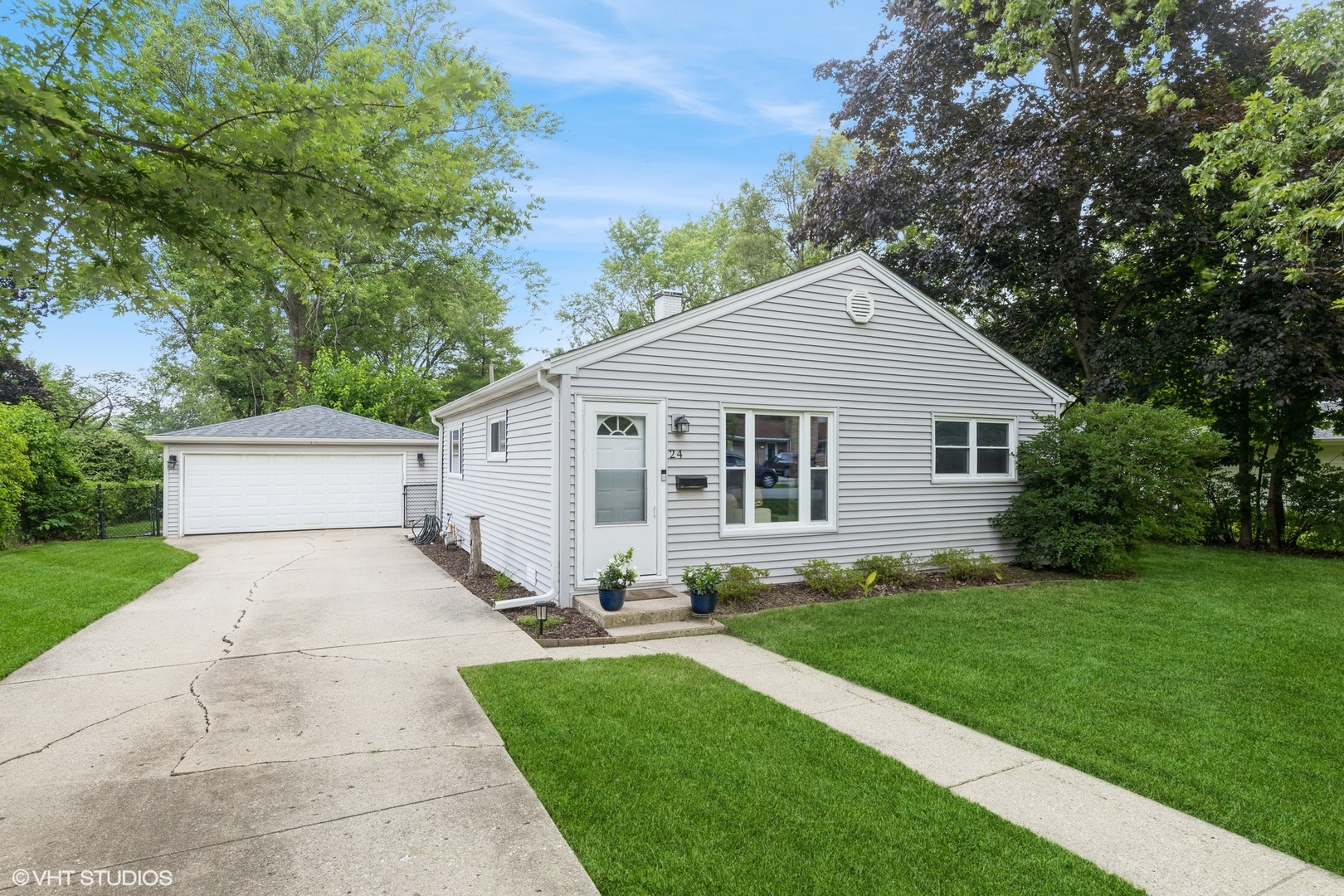 a view of a yard in front of a house with large trees