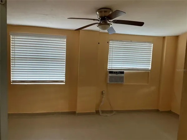 a view of room with a ceiling fan and a window