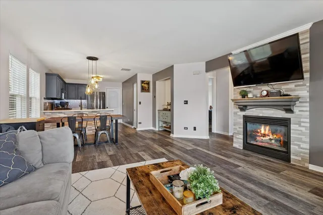a living room with furniture a flat screen tv and a fireplace