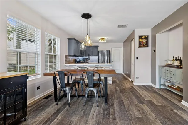a dining room with furniture a chandelier and wooden floor