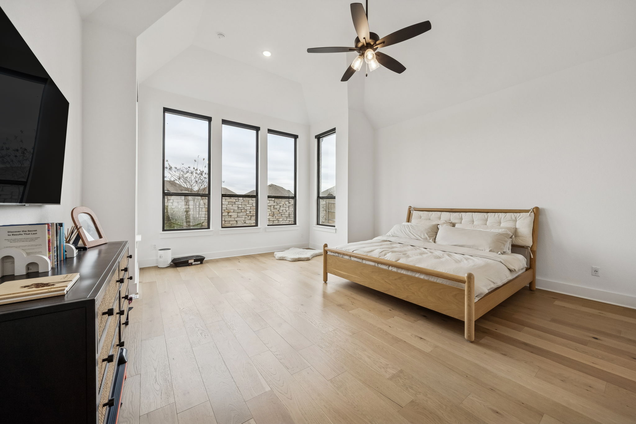 269 Iron Crk Way Kyle, TX 78640 - Photo 15 of 32 a spacious bedroom with a bed a flat screen tv and a large window