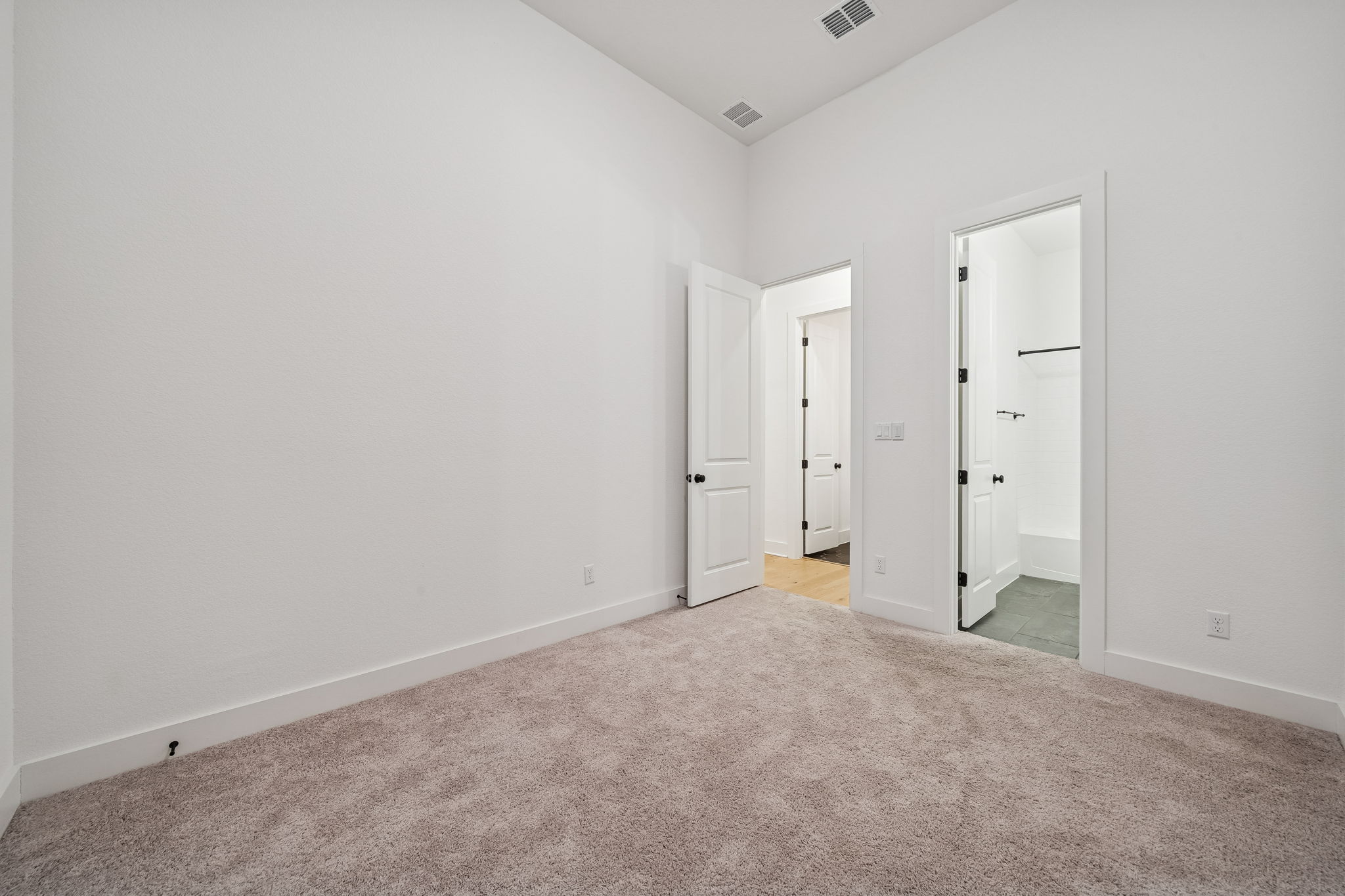 269 Iron Crk Way Kyle, TX 78640 - Photo 25 of 32 Unfurnished bedroom with light carpet and connected bathroom