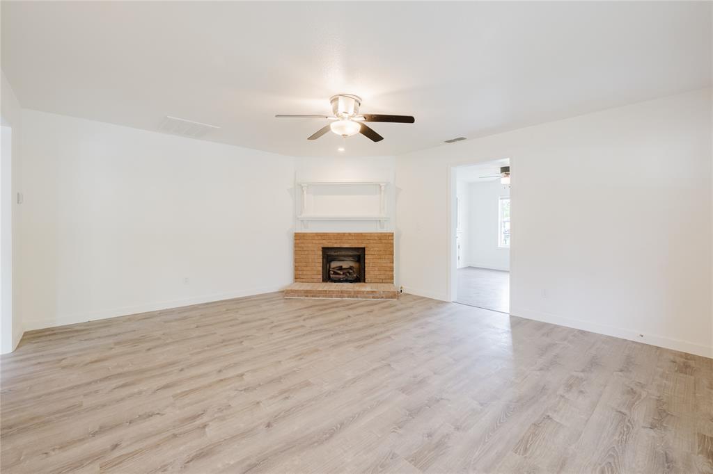 524 West Roberts Street Gorman, TX 76454 - Photo 7 of 35 wooden floor that has a fireplace in it