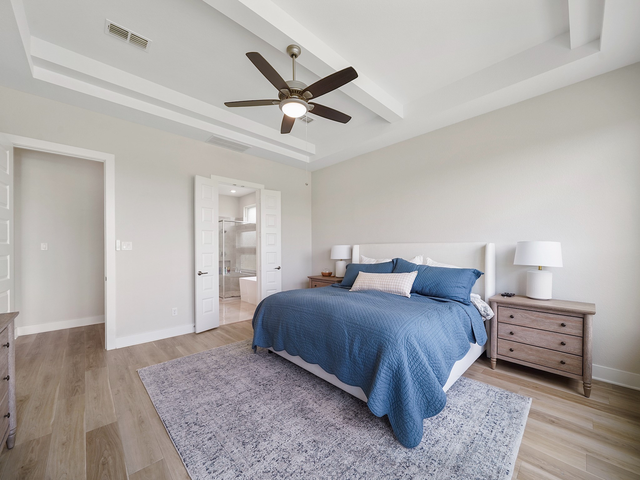 5802 Emerald Ranch Lane Fulshear, TX 77441 - Photo 23 of 45 The luxurious primary bedroom combines comfort and sophistication with elevated ceilings, expansive windows, and direct access to the spa-inspired ensuite bath.