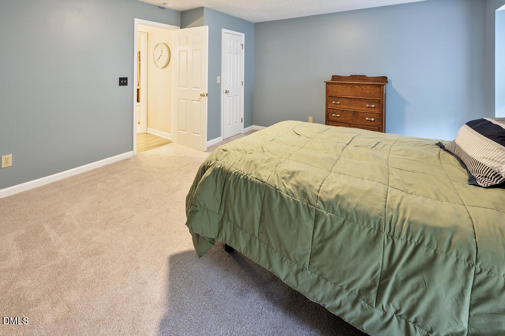 412 Oak Hollow Court Raleigh, NC 27613 - Photo 13 of 24 a bedroom with a bed and painting on the wall