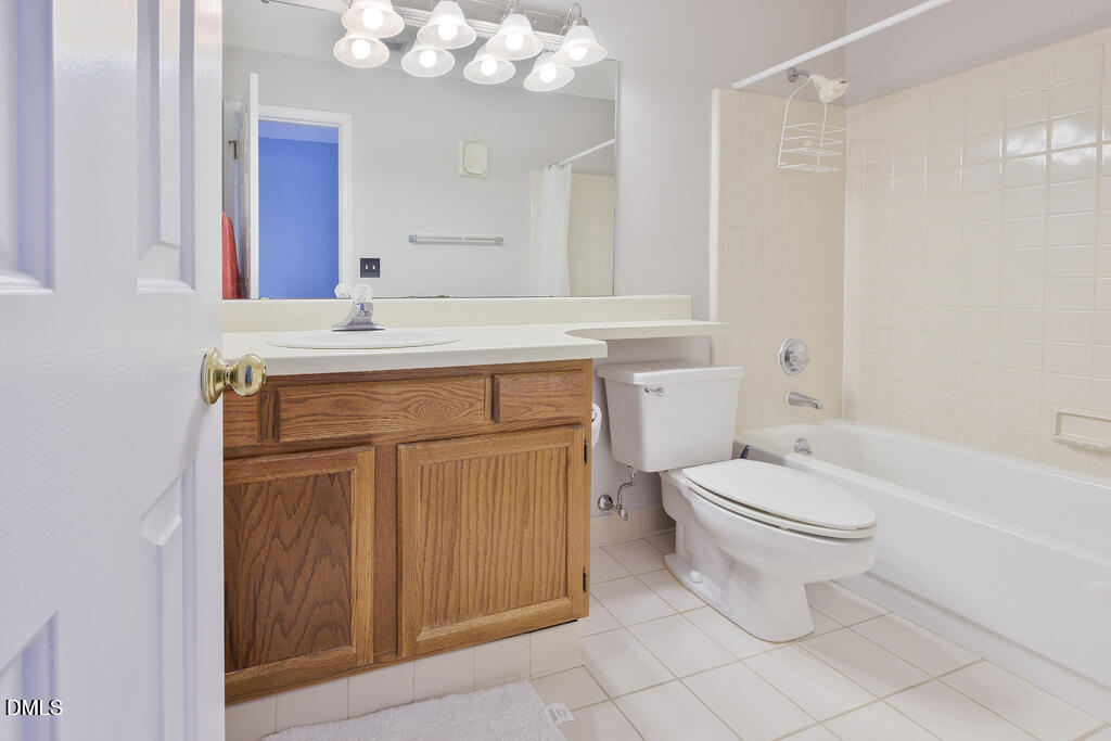 412 Oak Hollow Court Raleigh, NC 27613 - Photo 18 of 24 a bathroom with a toilet a sink a mirror a vanity and bathtub