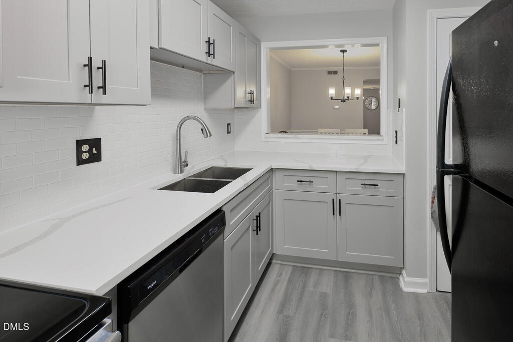 412 Oak Hollow Court Raleigh, NC 27613 - Photo 3 of 24 a kitchen with white cabinets and refrigerator