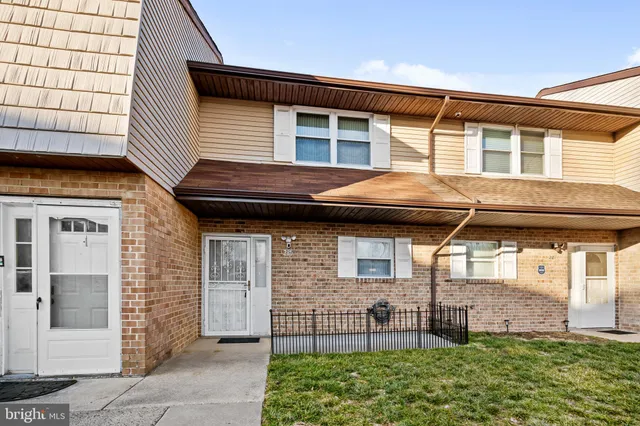 a view of a house with a small yard and wooden fence
