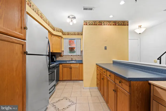 a kitchen with stainless steel appliances granite countertop a refrigerator and a sink