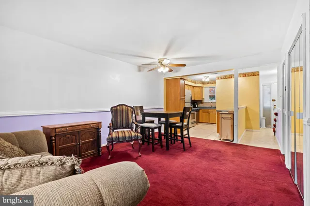 a living room with furniture a ceiling fan and a window