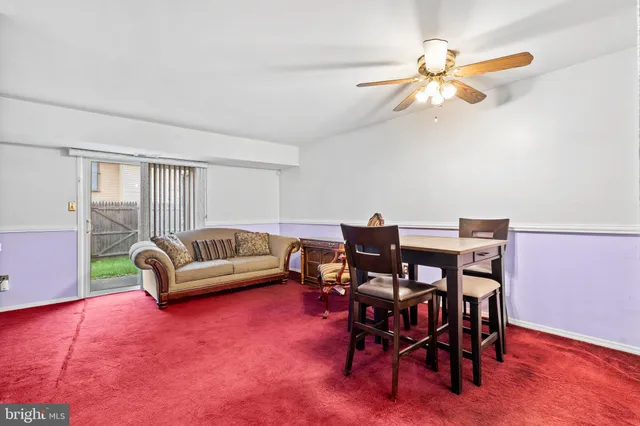 a living room with furniture a ceiling fan and a rug