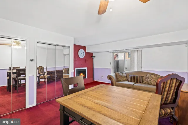a living room with furniture kitchen view and a wooden floor