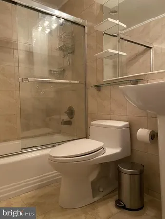 a white toilet sitting next to a bath tub and shower