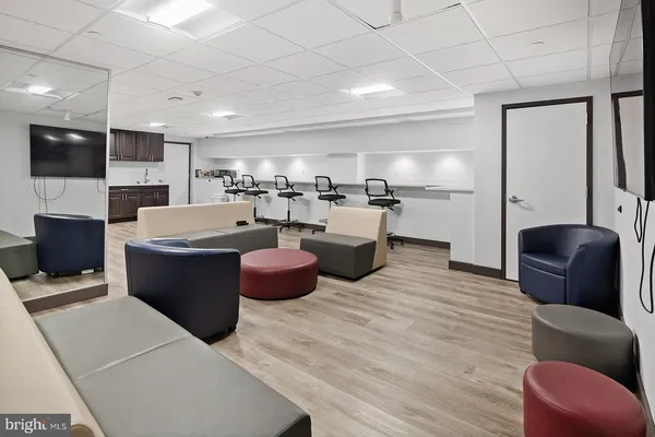 a large living room with stainless steel appliances kitchen island granite countertop a large couch and a flat screen tv