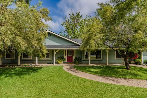 a view of a house with a yard and tree s