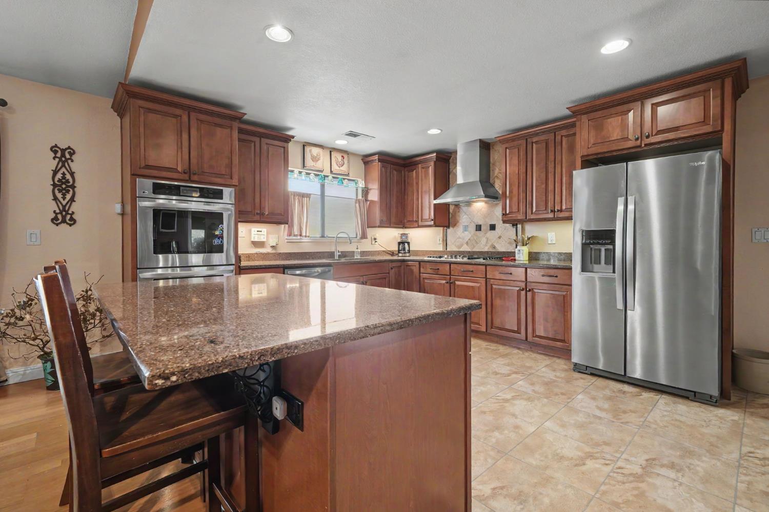 6364 Baldwin Street Valley Springs, CA 95252 - Photo 17 of 72 a kitchen with stainless steel appliances granite countertop a stove refrigerator and cabinets