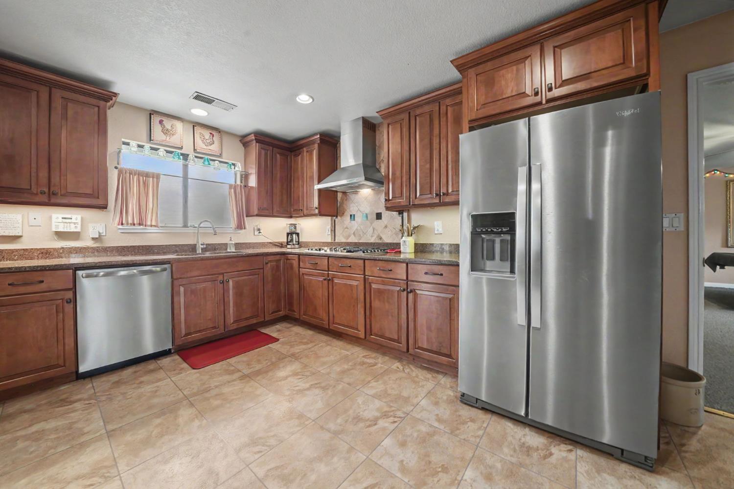 6364 Baldwin Street Valley Springs, CA 95252 - Photo 18 of 72 a kitchen with stainless steel appliances granite countertop a stove a refrigerator and a sink
