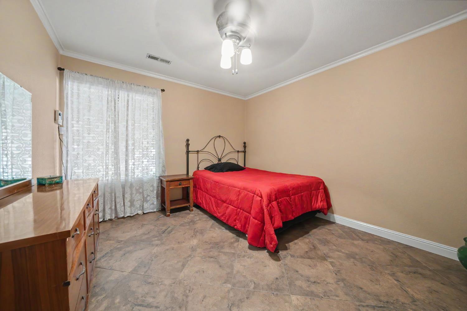6364 Baldwin Street Valley Springs, CA 95252 - Photo 35 of 72 a spacious bedroom with a bed and a chandelier