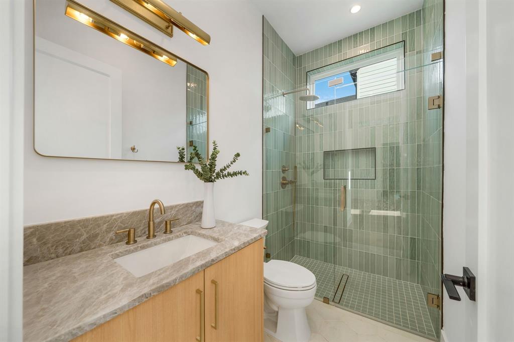 3627 Merrell Road Dallas, TX 75229 - Photo 28 of 39 a bathroom with a granite countertop sink a toilet and shower