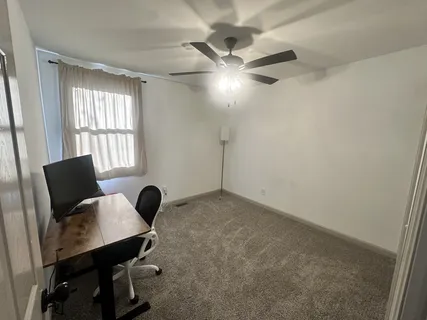 a view of a workspace with furniture and a window