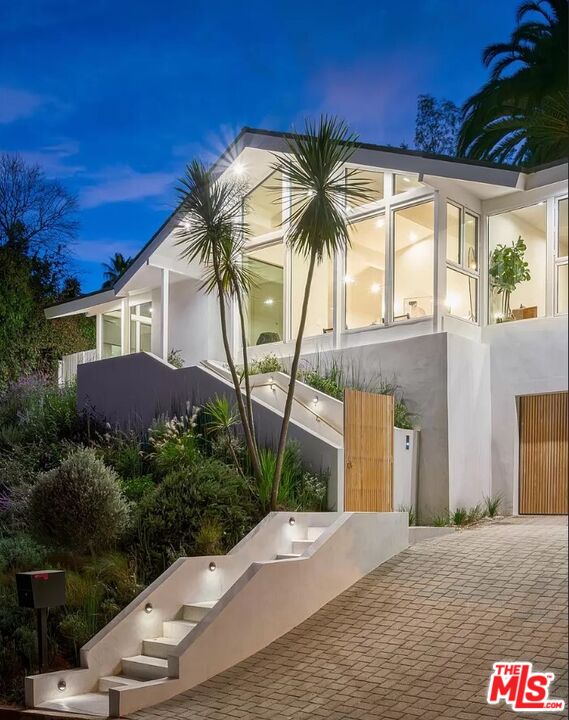 a view of a house with a yard and potted plants