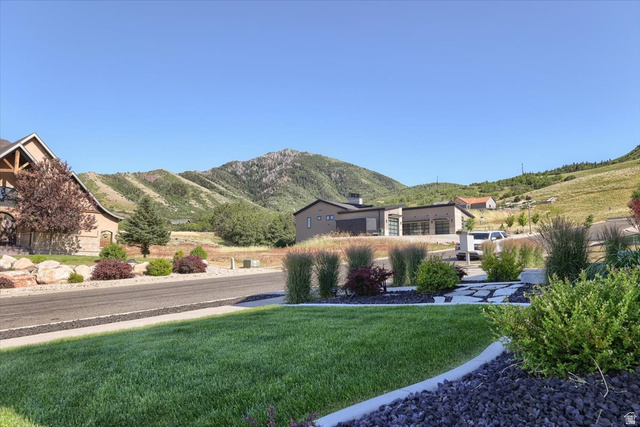 828 South Deer Road Tooele, UT 84074 - Photo 4 of 51 Expansive mountain backdrop with a manicured front lawn featuring decorative rock landscaping and mature plantings